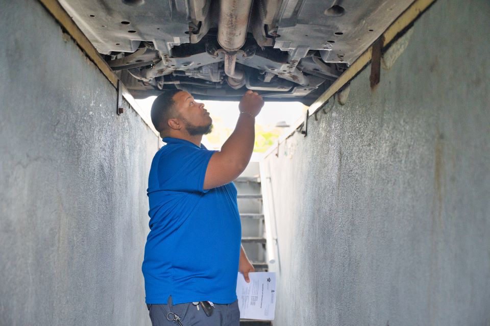 Civil Servant Inspects Vehicle from underneath.