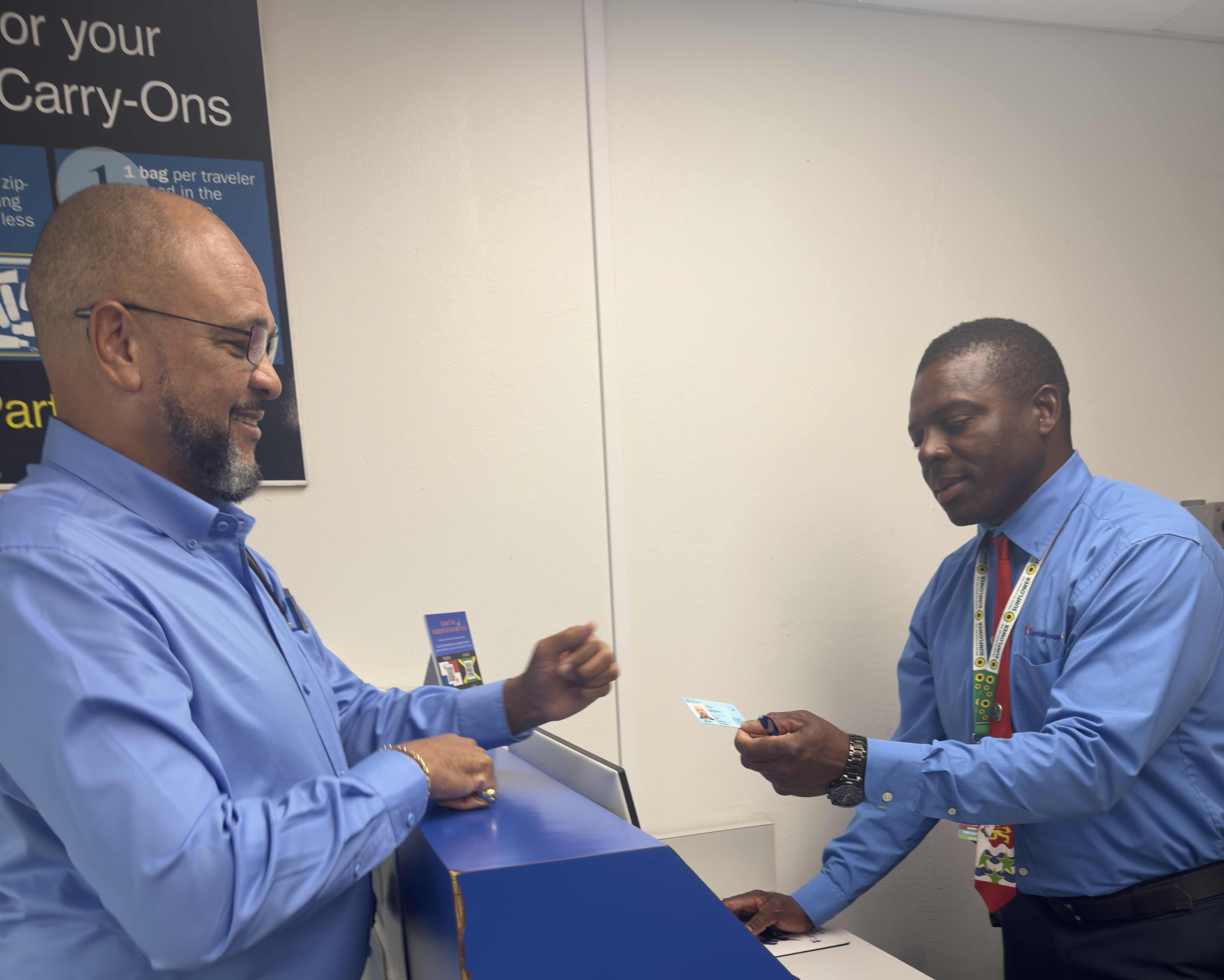 Minister Rankine presents his ID to airline staff before boarding the plane to Cayman Brac